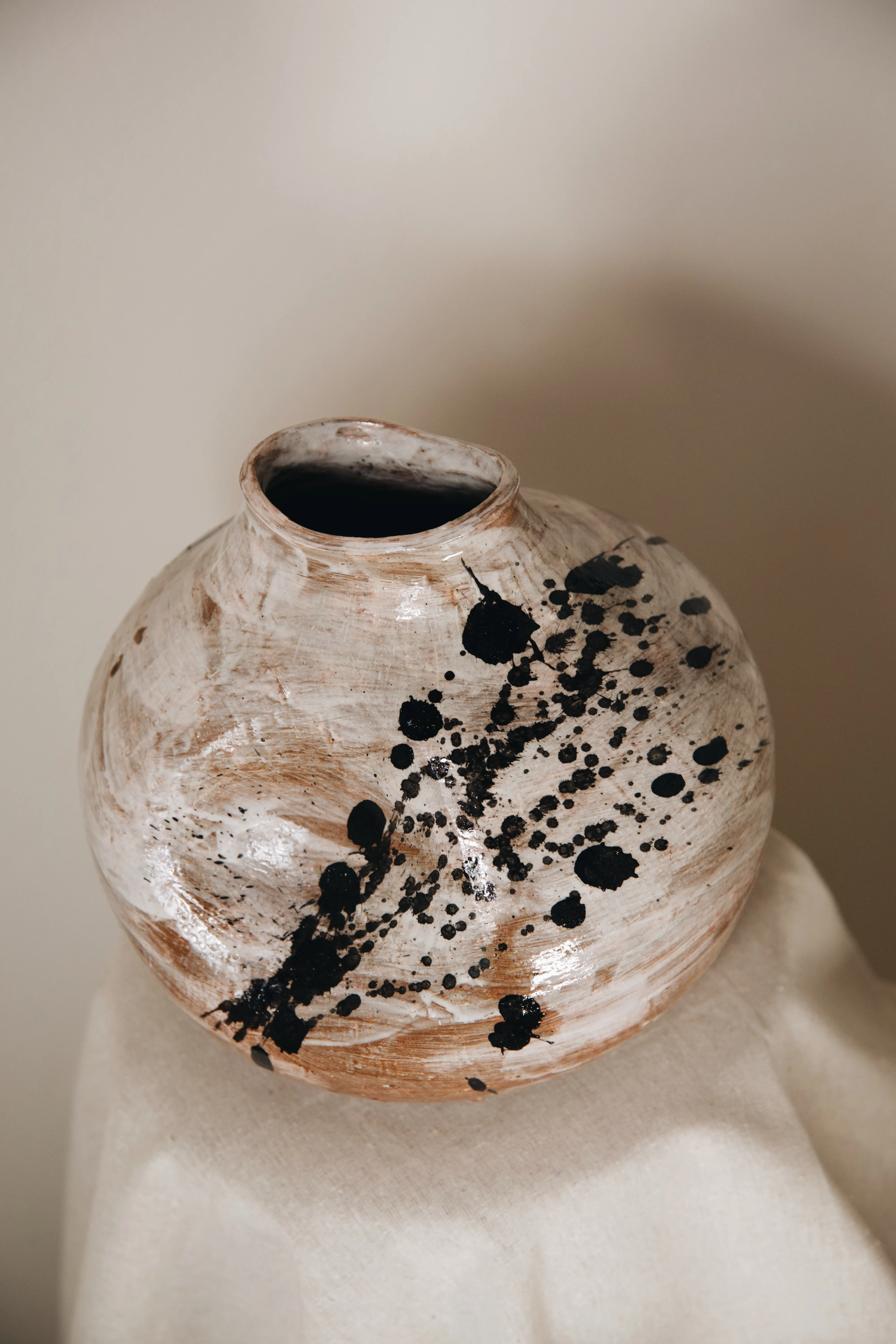 Vaso Gesto #05 visto de cima, boca pequena e manchas de tinta sobre o esmalte branco