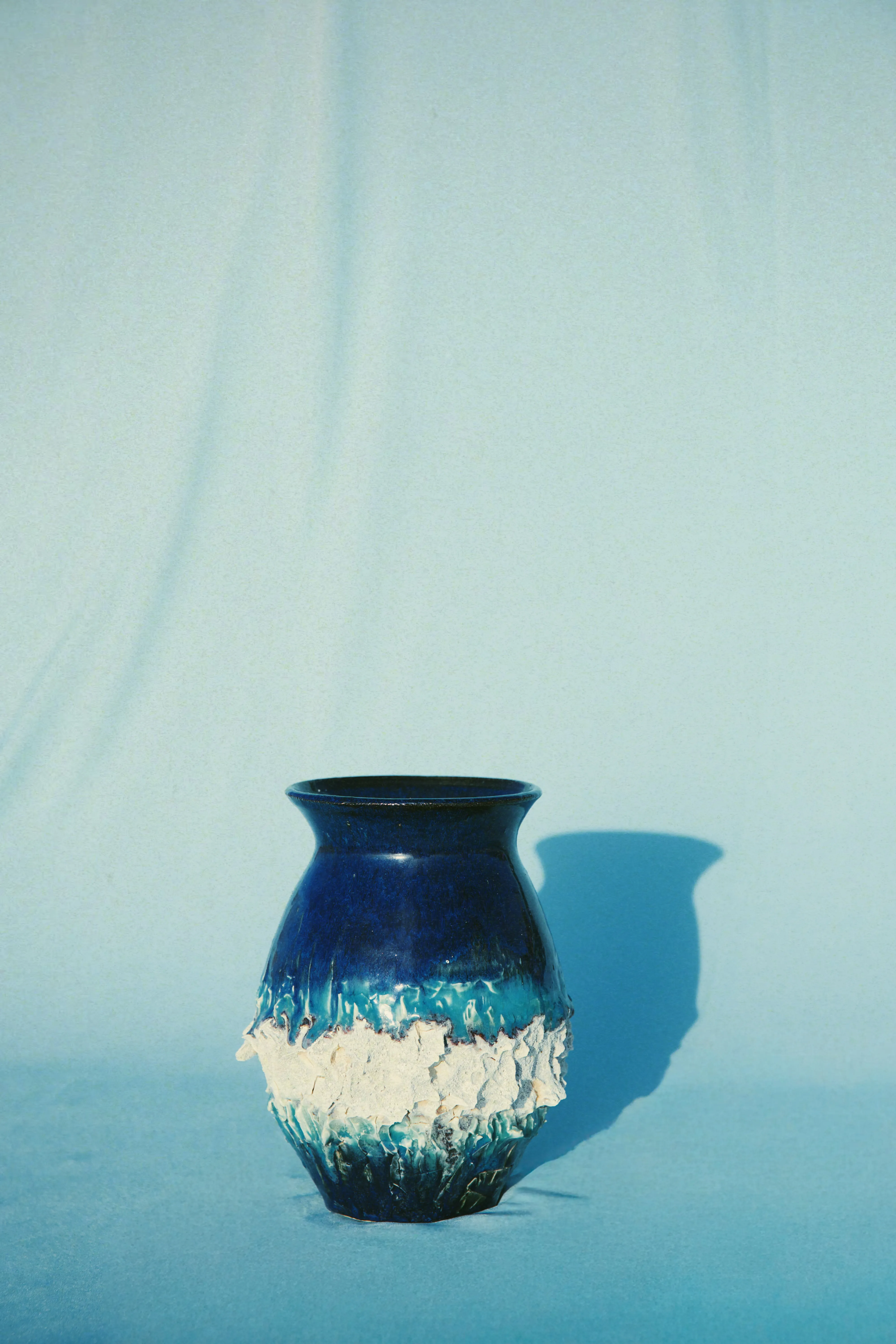 Vaso Mar #03 sobre tecido azul claro, esmalte azul profundo e faixa branca granulada